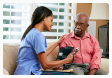 caregiver monitoring the blood pressure of his patient